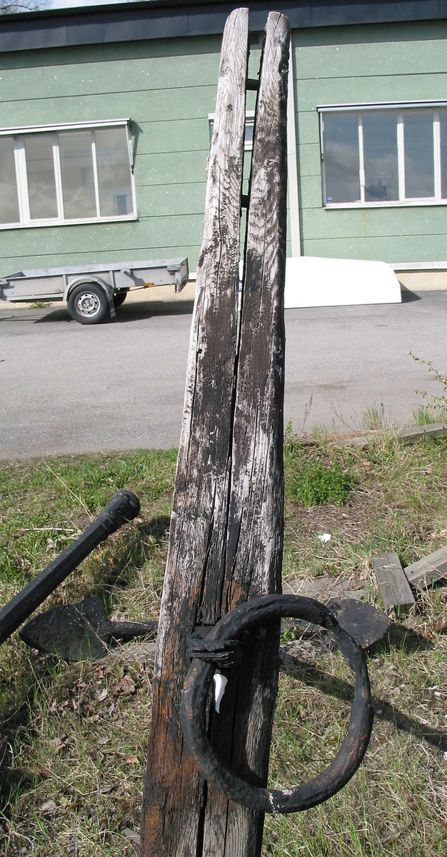 Ankarstock. Ena halvan av en ankarstock som är sammanfogade med den andra halvan med 8 dymlingar samt två bultar. Två kilar håller ankaret på plats.