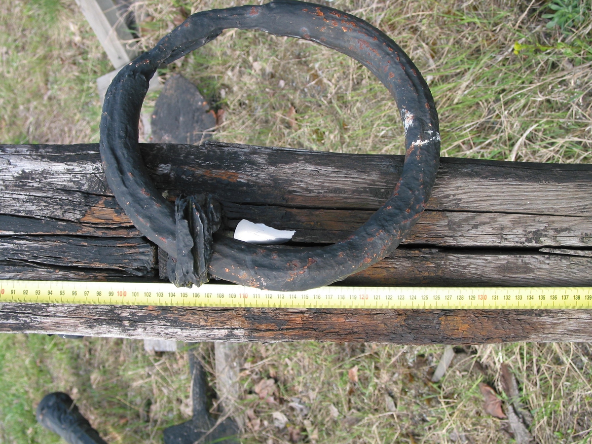 Ankarstock. Ena halvan av en ankarstock som är sammanfogade med den andra halvan med 8 dymlingar samt två bultar. Två kilar håller ankaret på plats.