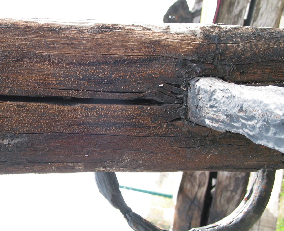 Ankarstock. Ena halvan av en ankarstock som är sammanfogade med den andra halvan med 8 dymlingar samt två bultar. Två kilar håller ankaret på plats.