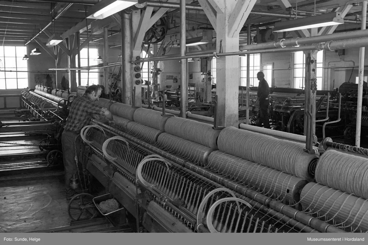 Arbeidsliv ved Salhus Tricotagefabrik i Salhus, Bergen i 1976. Arbeidarar ved selfaktor i 1900-bygget på Salhus Tricotagefabrik.