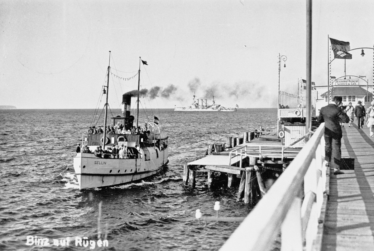 Text på bild: Binz auf Rügen.
Text på byggnad: Brückenkopf - Restaurant Conditorei & Cafe.