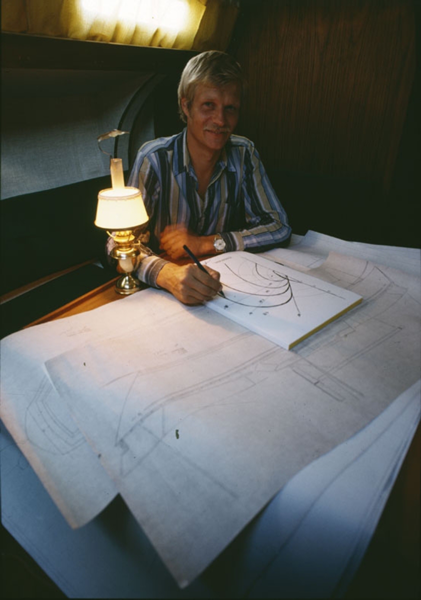 Båtkonstruktören Peter Norlin med ritningar vid salongsbordet i en Scampi 30.