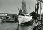 Holms skeppsvarv. Fiskebåten Västland (anm. felhört, hette Westland) för Styrsö Tången, Bohuslän, går av stapeln 1951. Stången med fartygets namnstandart sättes upp när fartyget tar vatten.
Skåne, Malmöhus län, Råå.