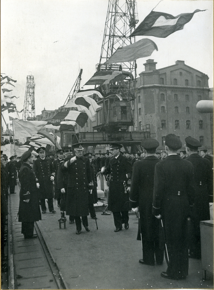 H.m. Konungen (Gustav V)besöker kryssaren Tre Kronor under besöket i Stockholm. General Thörnell bakom närmast konungen, t.v. Viceamiral Helge Strömbäck, C.M.