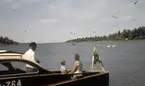 Mariehamn. Familj i motorjakt med flagga från Nyländska jaktklubben.