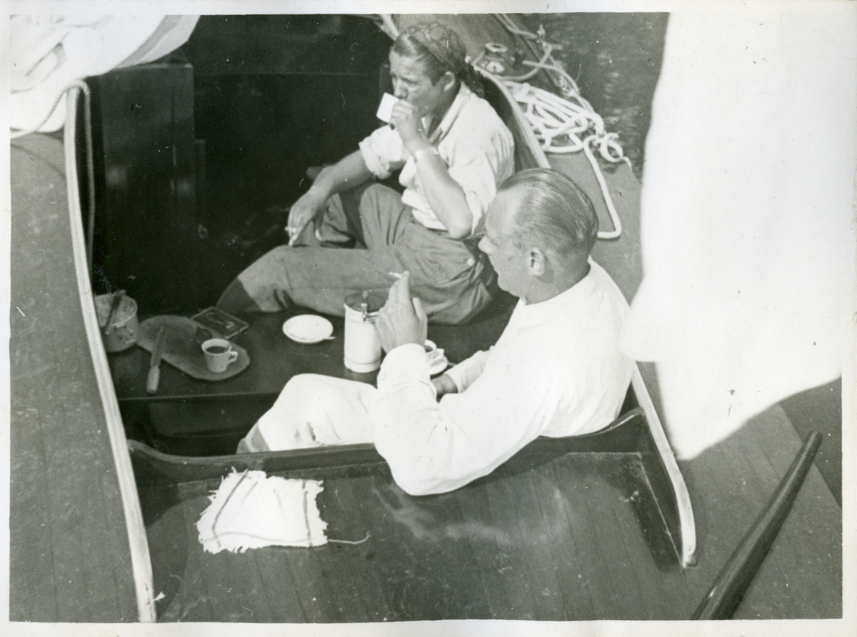 Carl Gösta Jackson (till höger) tillbringar en fikapaus med en cigarette i handen tillsammans med en oidentifierad vän. 1940/50-tal.
