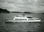 Till  vänster syns en del av Vasholmen samt därefter Getholmen och Notholmen. Till höger Askrikefjärdens förlängning ned mot Torsbyfjärd.
Fotodatum 1952-06-14