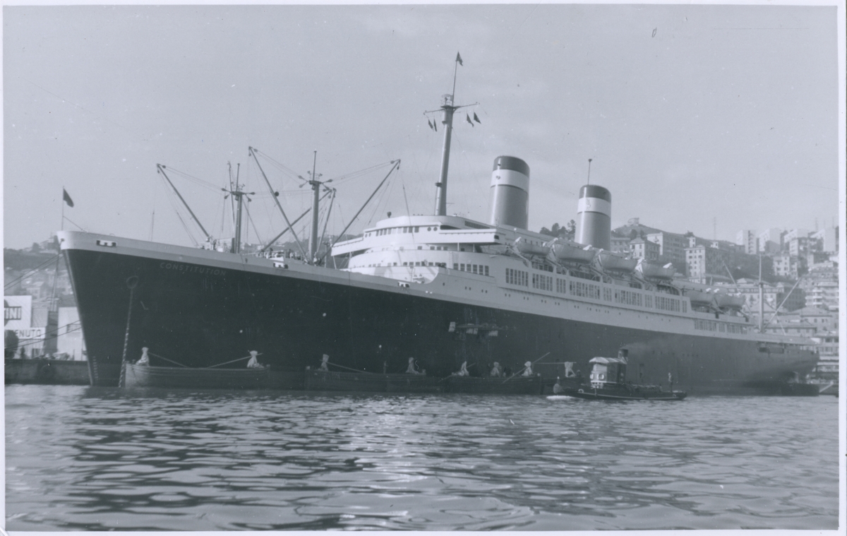 Vykort i svartvitt visande turist- & passagerarturbinångfartyg CONSTITUTION av New York vid kaj i Genoa 4/2 1955.
