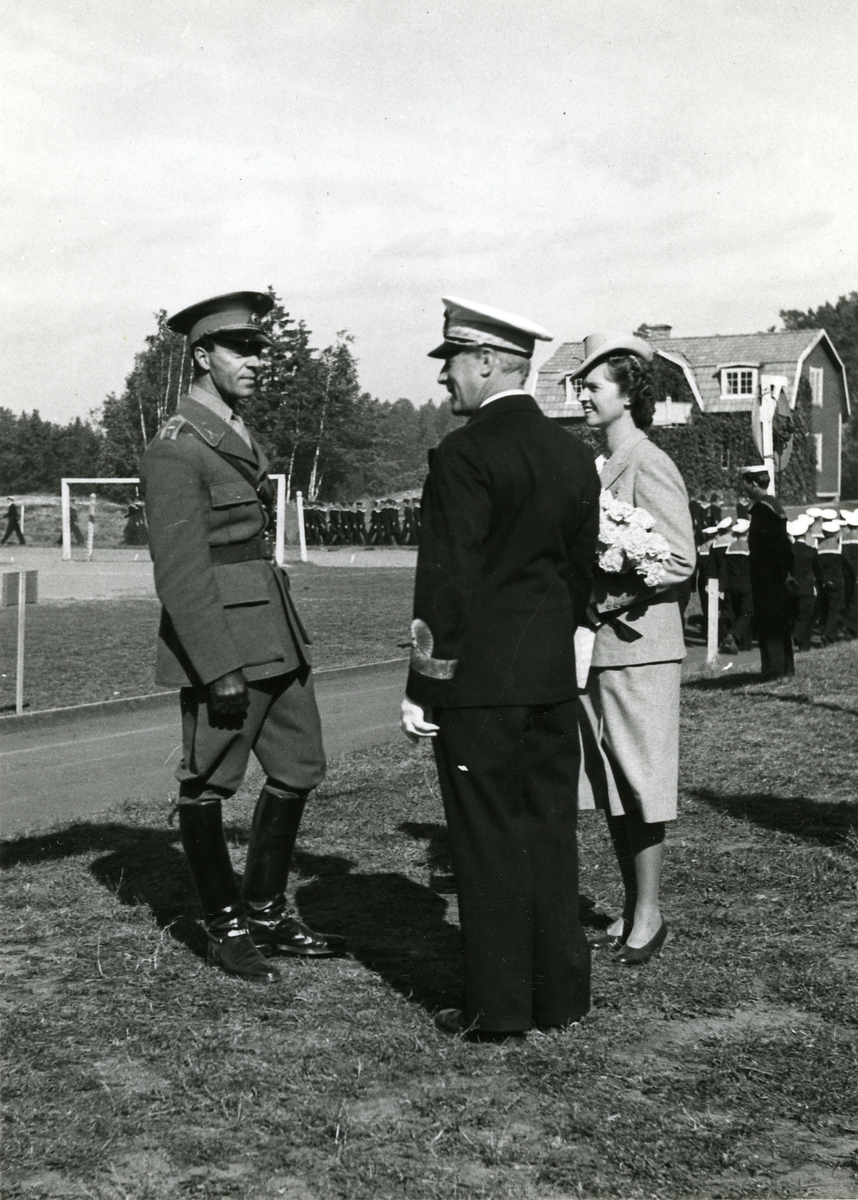 Foto visande H.K.H. prins Gustav Adolf med gemål prinsessan Sibylla i samspråk med konteramiral Sven Yngve Ekstrand.