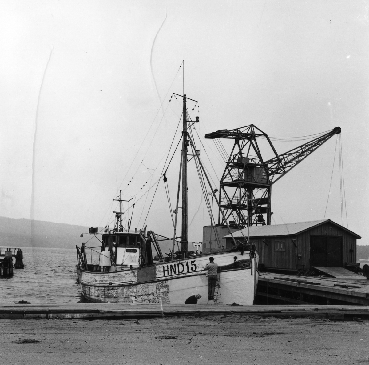 Lunde varv Ångermanland, Gudmundrå sn. Lunde.
Fiskebåt HND 15 från Härnösand inne på varvet för kölreparation. I bakgrunden syns en av varvets tre pontonkranar, med vilka man gör muddringsarbeten i egen regi längs ostkusten.