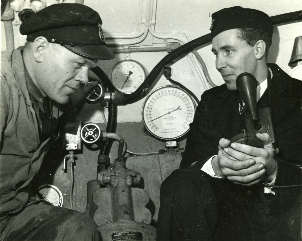 Bärgningsfartyget Belos (I).
Ubåtsklockan. Jung och maskinisten fotograferade på 20 m. djup (se djupmätaren) den 27 oktober 1942.