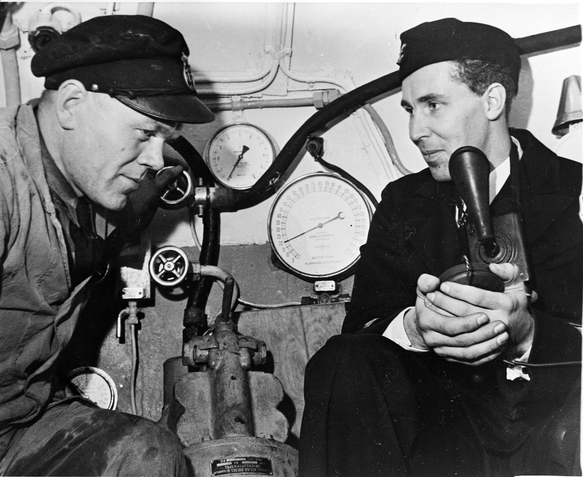 Bärgningsfartyget Belos (I).
Ubåtsklockan. Jung och maskinisten fotograferade på 20 m. djup (se djupmätaren) den 27 oktober 1942.