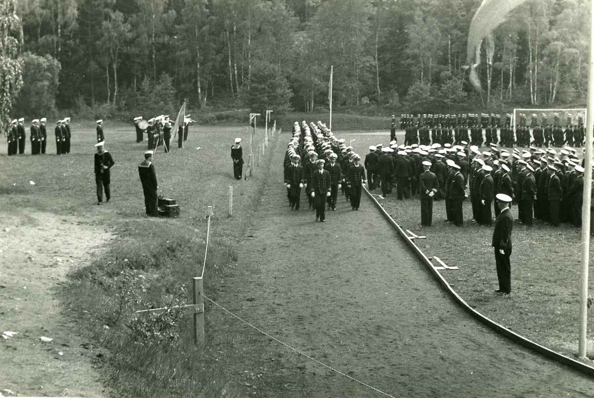 Fartygsbesättningar avtågar efter ceremoni vid Kustflottans idrottsplats vid Hårsfjärden.