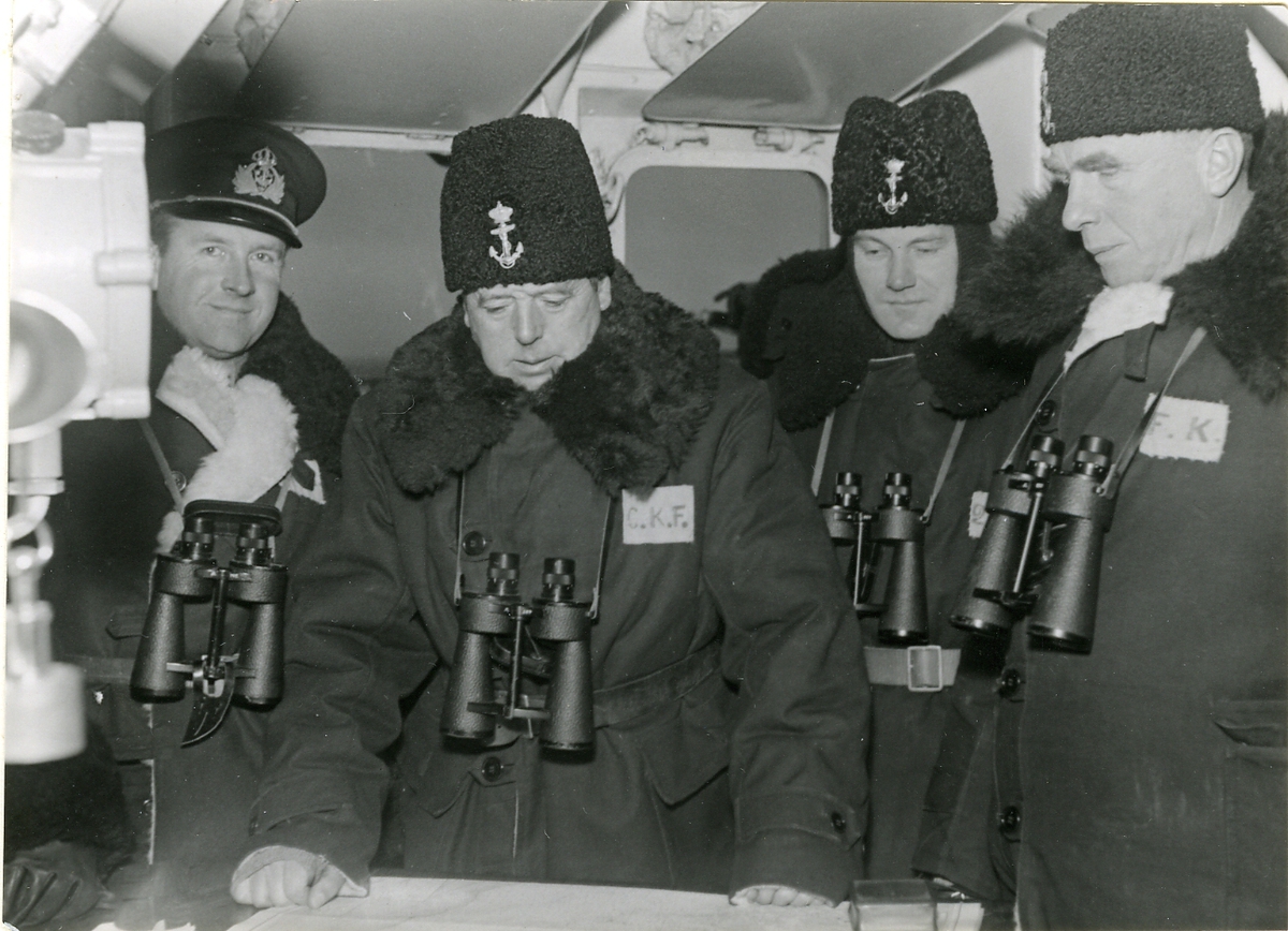 Chefen för kustflottan, konteramiral Gösta Ehrensvärd, och andra officerare klädda i vinterpälsar.