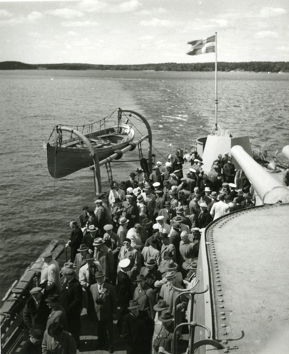 Civila besökare på akterdäck på pansarskepp under gång.