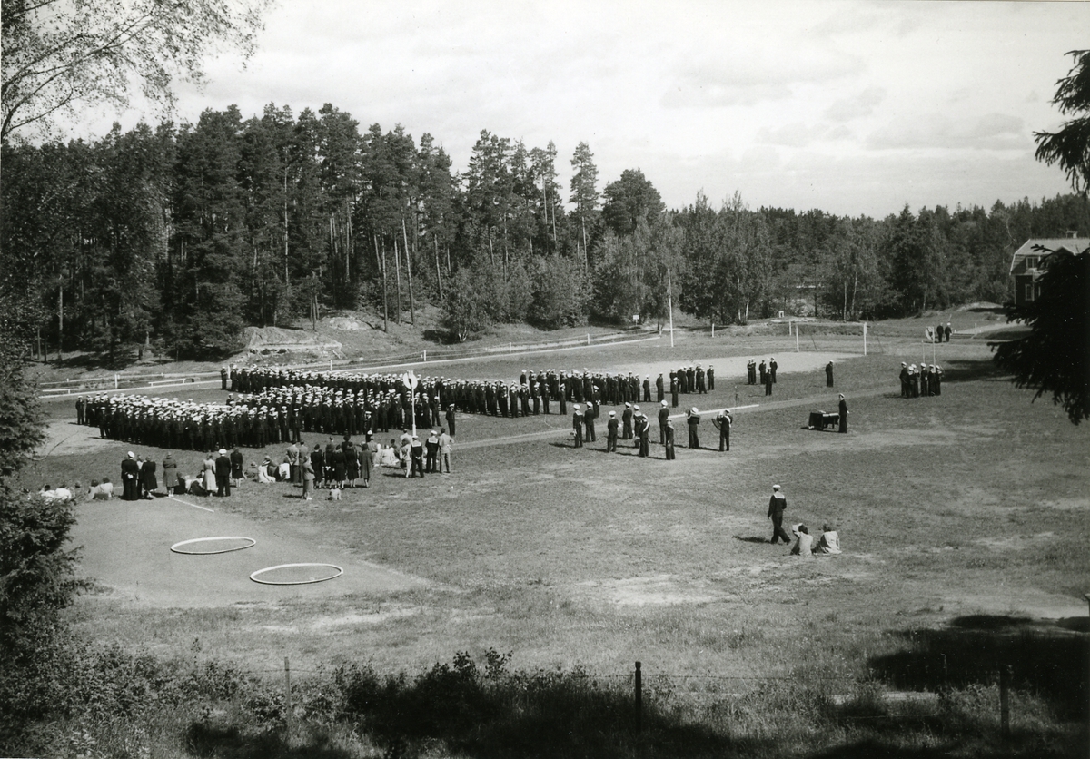 Avslutning med prisutdelning den 18 juni 1948.
Fartygsbesättningar uppställda på Kustflottans idrottsplats vid Hårsfjärden.
