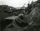 Kryssaren Göta Lejon tar ombord minor. Minorna körs ut på kajen från ett bergrum 1948.