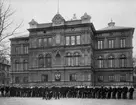 [från fotobeskrivningen:] Sjökrigsskolan på Skeppsholmen år 1907. Framför står flottans kadettkår.