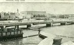 Stockholm, Skeppsbron omkr. 1900.
Utsikt från Skeppsholmen mot Kungl. slottet. Bild av badhuset på Skeppsholmen.