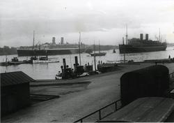 Två större turistångfartyg liggande på Stockholms ström. Sta