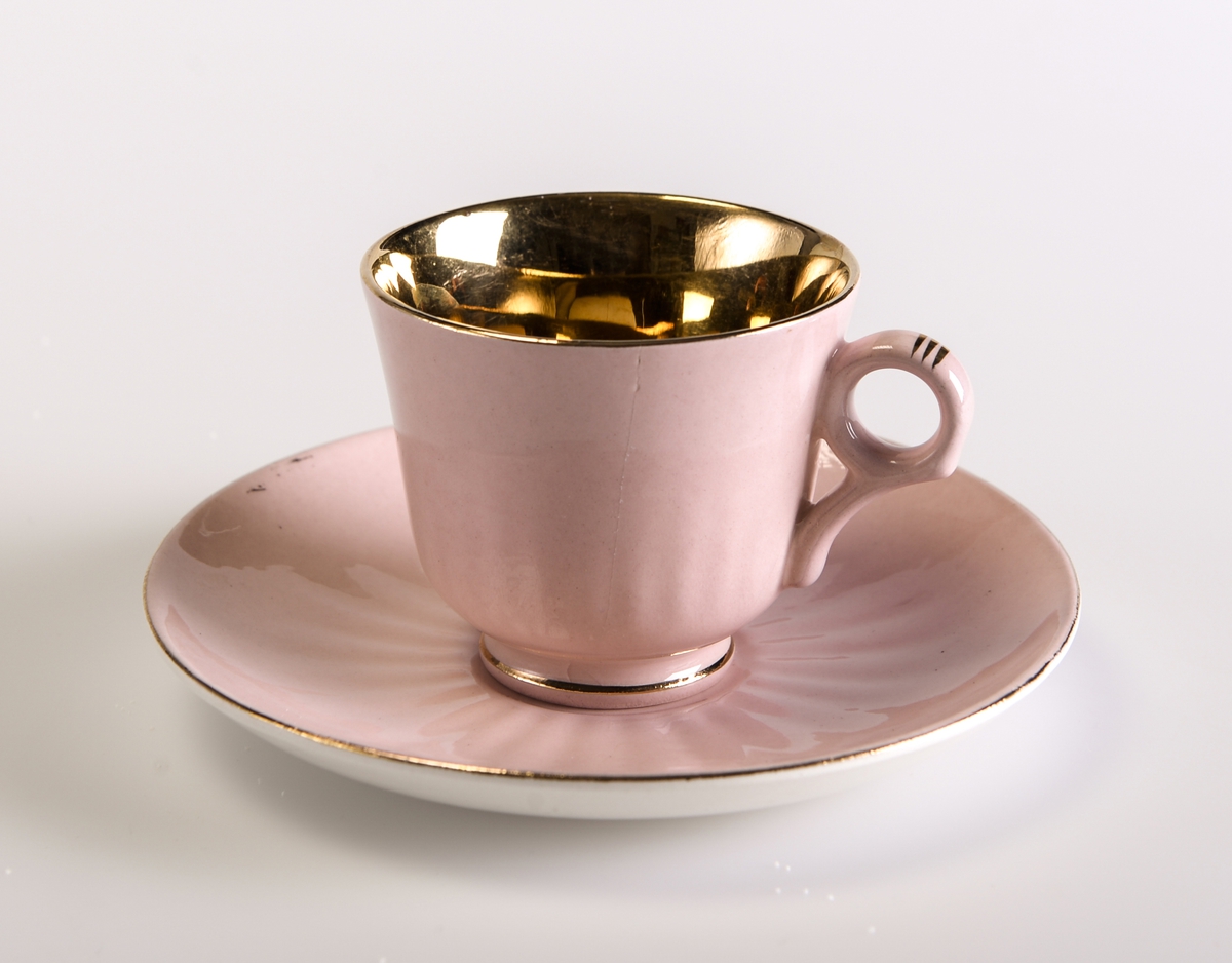 En rosa kopp med asjett, og en blå kopp med asjett. Koppene er gulldekt på innsiden og fatene har gullkant.