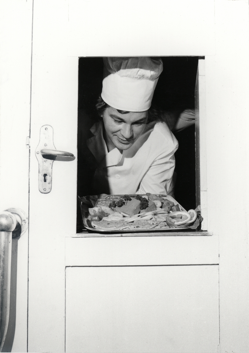 Kocken Jorma Ruuskanen sätter fram mat i kabyssdörrens lucka på isbrytaren SANKT ERIK.