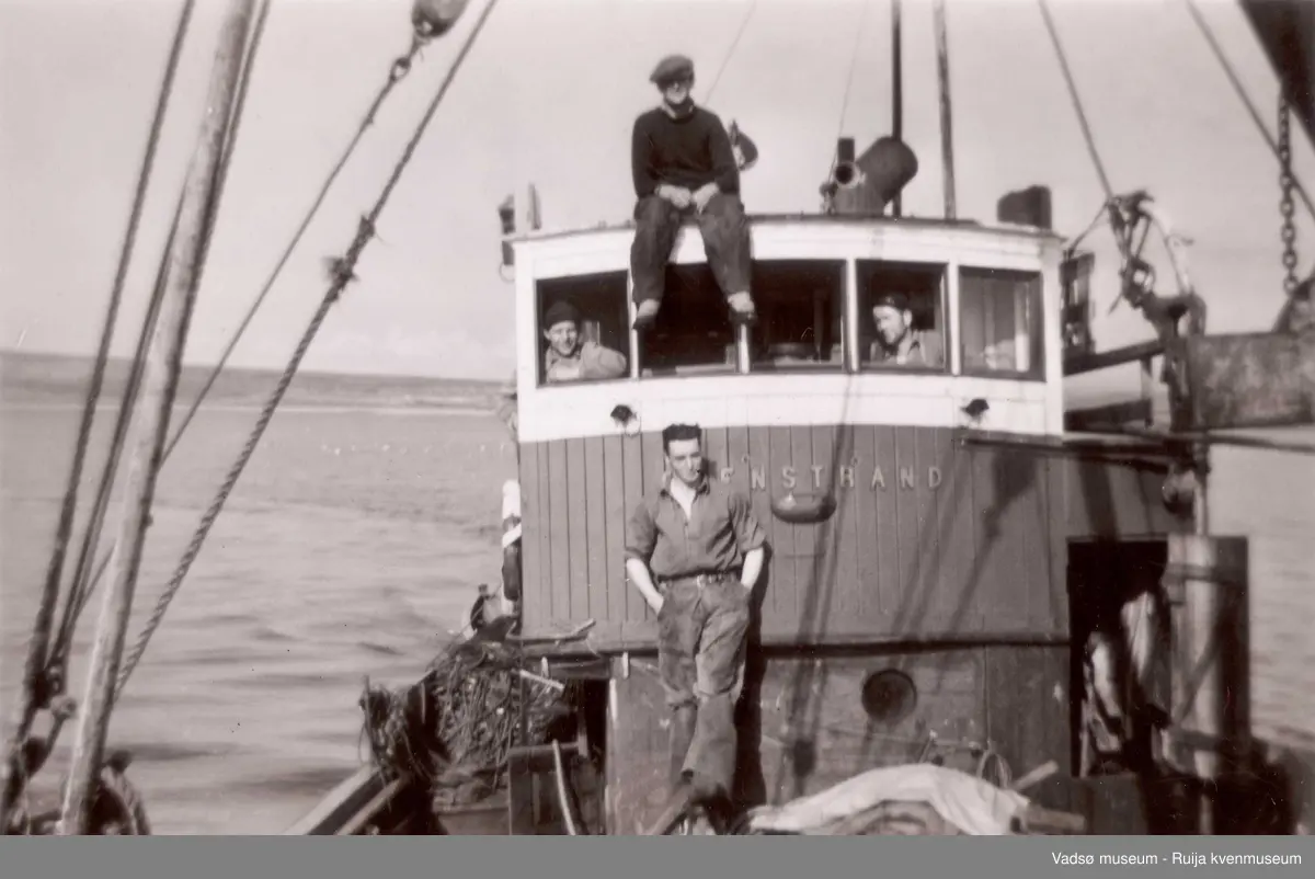 Båten Stenstrand ant. på Lofotfiske i 1952. På rorhustaket: Arvid Mentujærvi, Venstre vindu: Karl Mettio, foran rorhus: Alf Herstrøm 
Høyre vindu: Alfred Bietilæ 
