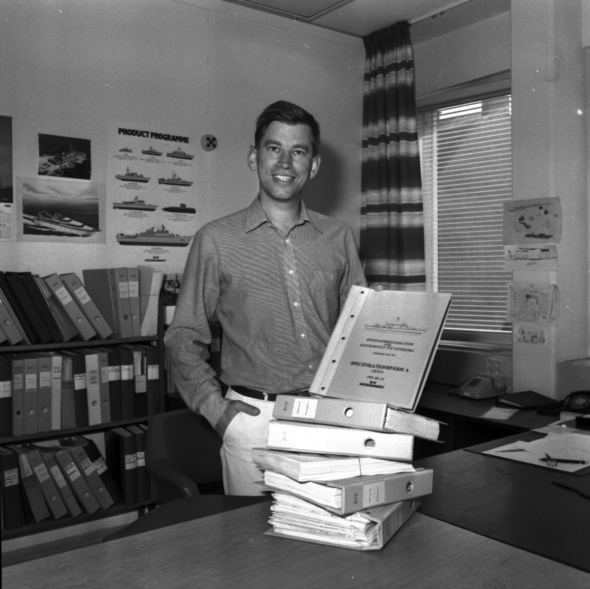 Varvet runt- en bildutställning
Civilingenjör John Nilsson, Kontruktionskontoret, med offerthandlingarna för kustkorvett typ Göteborg 1985.\\Sedan 1970-talet har Konstruktionskontorets tekniska kompetens förstärkts, bl a genom en markant ökning av högskoleutbildad personal.