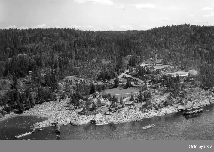 Flyfoto. Ingierstrand bad. Et yrende badeliv på sjø og land. Badebåten lagt til fergebrygga.