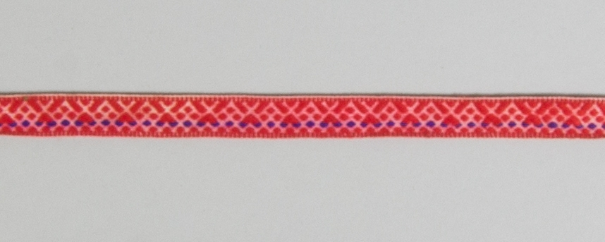 Kjolsäck till dräkt för kvinna från Bjursås socken, Dalarna. Modell med avskuret framstycke. Tillverkad av svart ylletyg, vadmal, med broderi utfört med rött ullgarn och (troligen) silkegarn i flera färger: Motiv: centralt placerad större blomma från vilken bågformar utgår, på sidorna parvis tre andra blomformer. Konturer i kedjesöm, utfyllnader i flätsöm och sticksöm. På överstycket två rader flätsöm på höger sida. Framstycket fodrat med fabrikstillverkat vitt linnetyg, tuskaft. Kantat runtom med diagonalvävt rött ylleband. Bakstycke av handvävt linnetyg, kypert. Midjeband handvävt, med plockat mönster av rött ullgarn på vit botten, en blå mönstertråd. Två hyskor och en hake av svart metall.