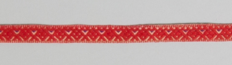 Kjolsäck till dräkt för kvinna från Bjursås socken, Dalarna. Modell med avskuret framstycke. Tillverkad av svart ylletyg, vadmal, med broderi utfört med rött ullgarn och (troligen) silkegarn i flera färger: Motiv: centralt placerad större blomma från vilken bågformar utgår, på sidorna parvis tre andra blomformer. Konturer i kedjesöm, utfyllnader i flätsöm och sticksöm. På överstycket två rader flätsöm på höger sida. Framstycket fodrat med fabrikstillverkat vitt linnetyg, tuskaft. Kantat runtom med diagonalvävt rött ylleband. Bakstycke av handvävt linnetyg, kypert. Midjeband handvävt, med plockat mönster av rött ullgarn på vit botten, en blå mönstertråd. Två hyskor och en hake av svart metall.