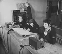 Försöksanläggning för luftförsvarsgruppcentral, Lgc, i lektionsalsbyggnaden på F 13, 1951. En militär och tre luftförsvarslottor i arbete.