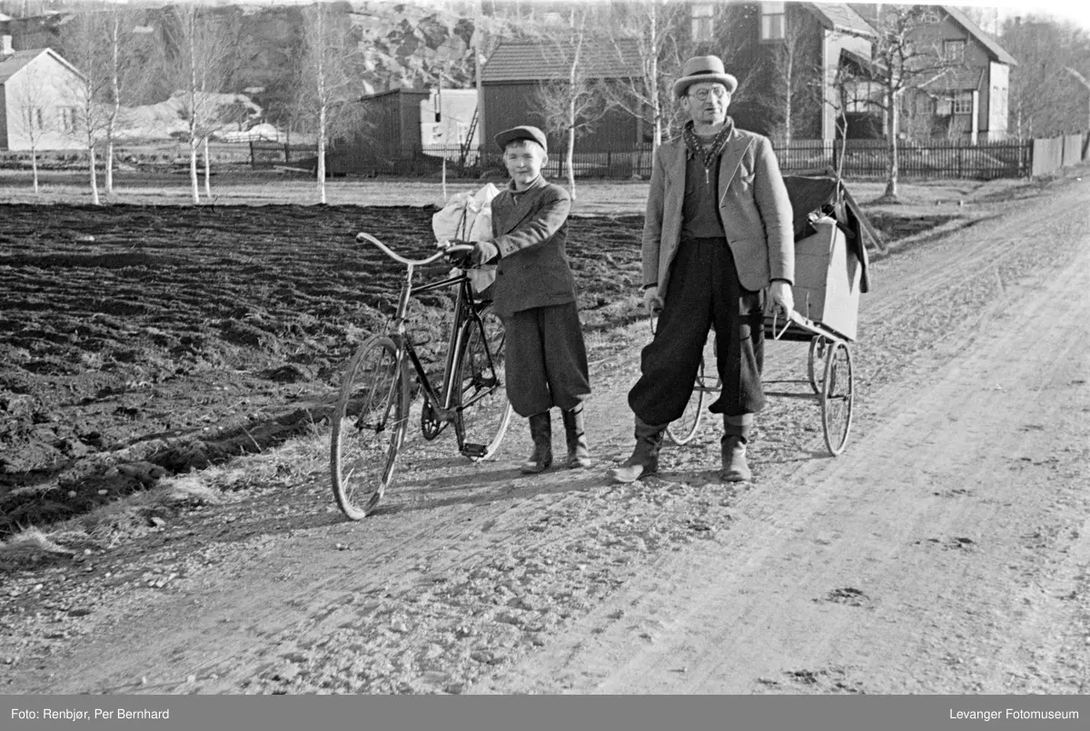 Levanger april 1940. Evakuering av byen i frykt for at den vil bli bombet. Hermann Wikdahl og hans far Leonhard Wikdahl. Bildet er tatt i Gamle Kongeveg. I bakgrunn sees Gamle Kongeveg 64 og alléen som Linus Jensen plantet.