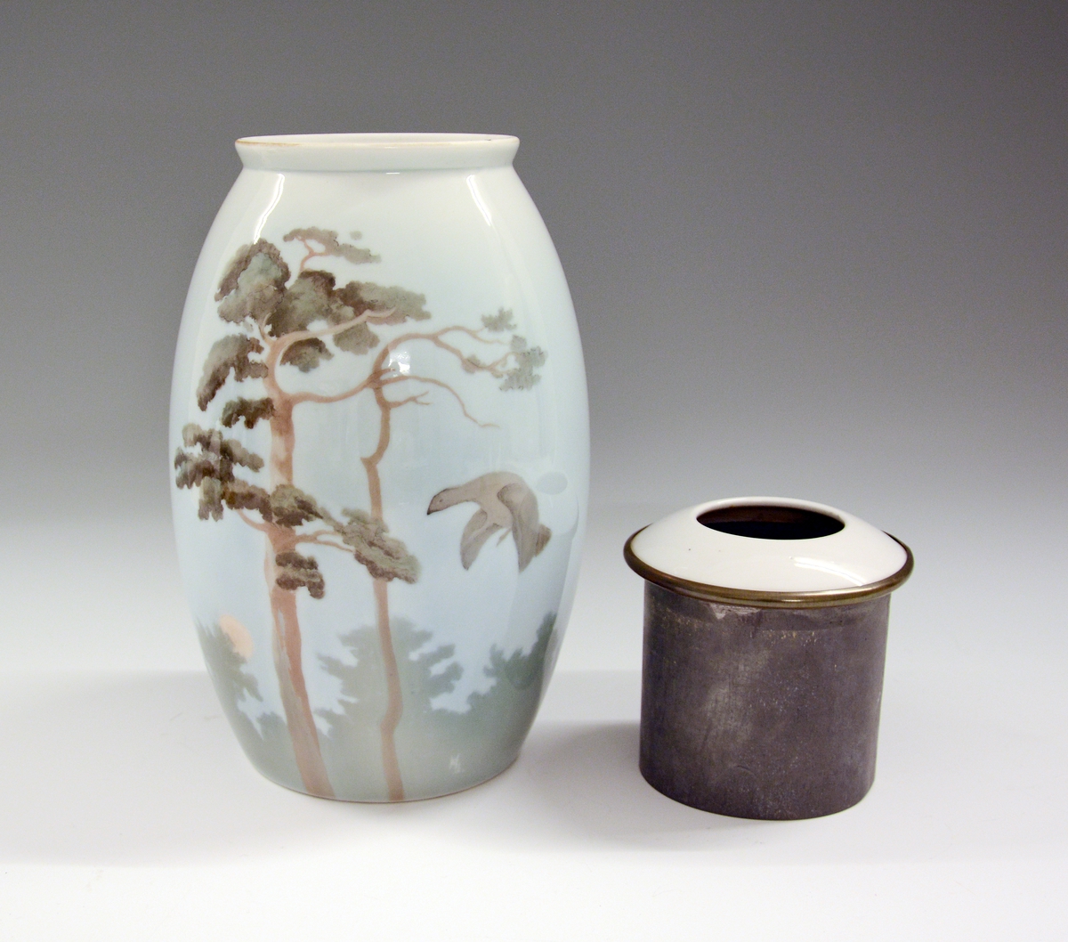 Vase av porselen. Underglasurdekor.
Modell 1723.
Dekornr. 120 Furu og røi tegnet av Halfdan Gran.
Ustemplet.
Gjort om til lampefot.