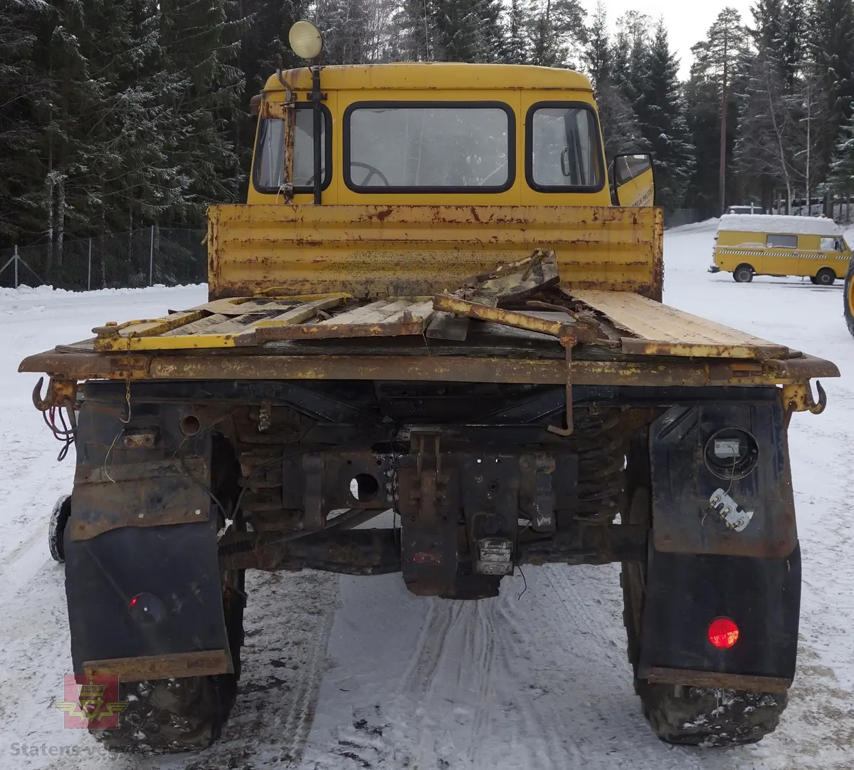 MB Unimog 406. Lastebil på 4 hjul, (to akslet), med akselavstand 240 cm. I hovedsak gul. 4-hjuls drift. Kjøretøyet har for fremdrift en 6-sylindret dieselmotor, antatt av typen M.B OM 352 X 11 fra Mercedes Daimler Benz. Motoren yter 84 Hk (61,76 KW) og har et slagvolum på 5700 kubikkcentimeter.
Schmidt standard frontmontert redskapsfeste. Antall seter er 2. Standard dekkdimensjon skal være 12,5-20 rundt om.