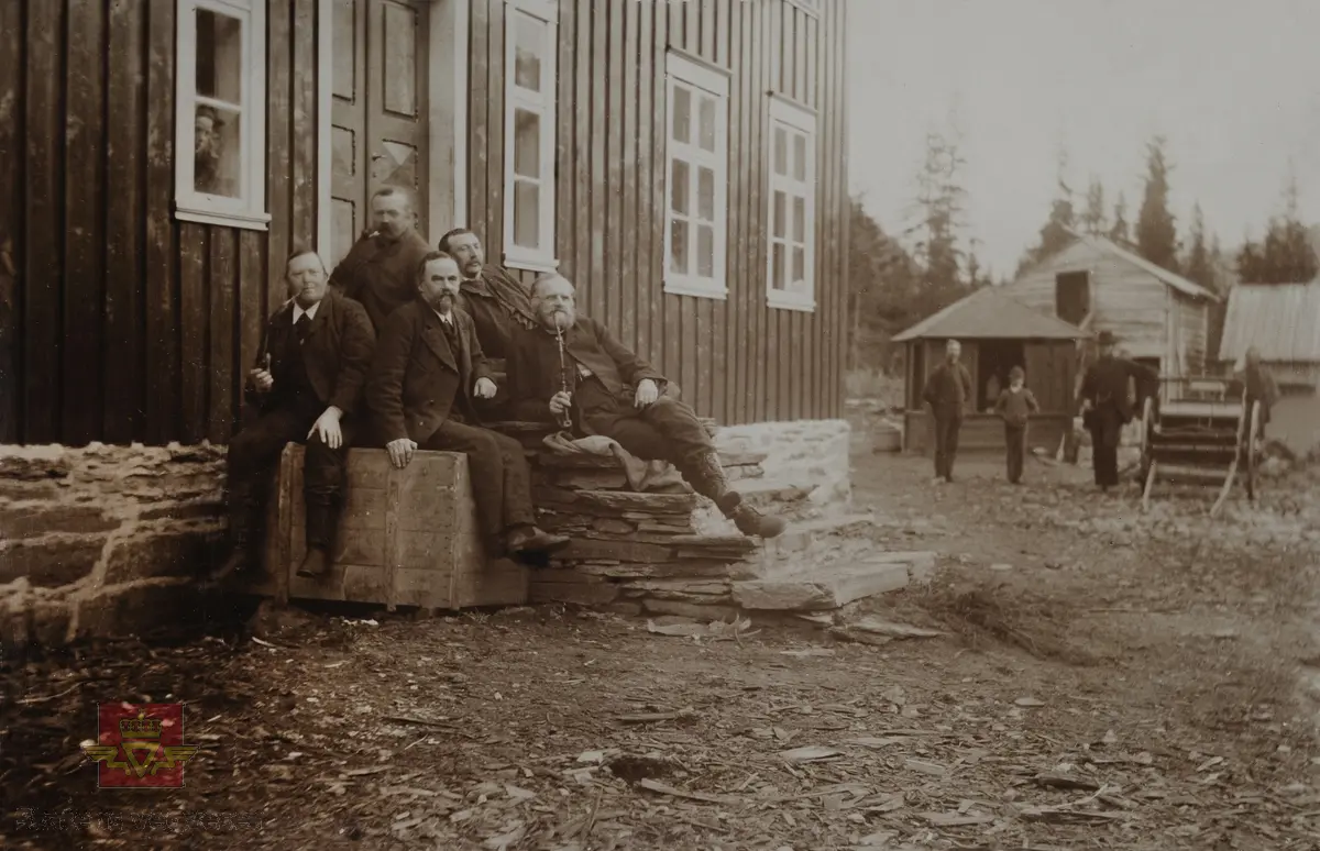 "Veianlæg". "Mortenslund i Grong".  Vegdirektør Hans Hagerup Krag sitter  i midten på fremste rekke. Han ble tilsatt i Vegvesenet i 1852 og ble vegdirektør og leder av Vegdirektoratet fra 1873. Han er kjent for planlegging av mange store vegprosjekt her i landet, som Geirangervegen, Haukelivegen, Strynefjellvegen og Sognefjellvegen for å nevne noen.  Tjenestetid  i vegvesenet var fra 1852 - 1903. På bildet er han sannsynligvis  på befaring med andre vegingeniører og vegbestyrere.  Til høyre på bildet med lang pipe sitter vegingeniør/vegbestyrer Henrik Christopher Sommerschild,, med tjenestetid i vegvesenet fra 1853 - 1900. Bak sitter  daværende løytnant Klæstad, med tjenestetid i vegvesenet fra 1877 - 1892. Til venstre og bak på bildet sitter to ukjente menn med lang og kort pipe. 
Bildet er illustrert i "Meddelelser fra Veidirektøren", Nr. 8-1929, jf. "Veidirektør Hans H. Krag 9. august 1829 - 9. august 1929".