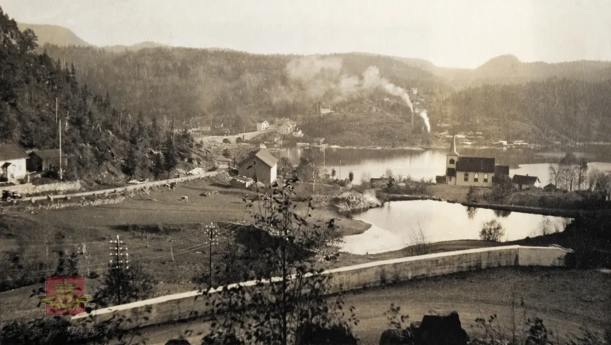 "Veianlæg". Østover mot Langangen. Støpt rekkverk i vegen. Trehusbebyggelse og kirke.