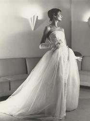 Mannekäng i vit klänning med släp i tyll, vita aftonhandskar