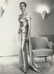 Mannekäng i glittrig aftonklänning med släp och rosetter. NK