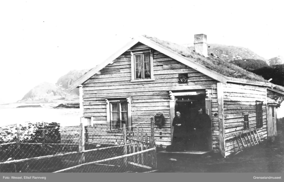 Poståpneri og tollstasjon i Grense Jakobselv. Carl Peder Olson med frue Marthine i døra.