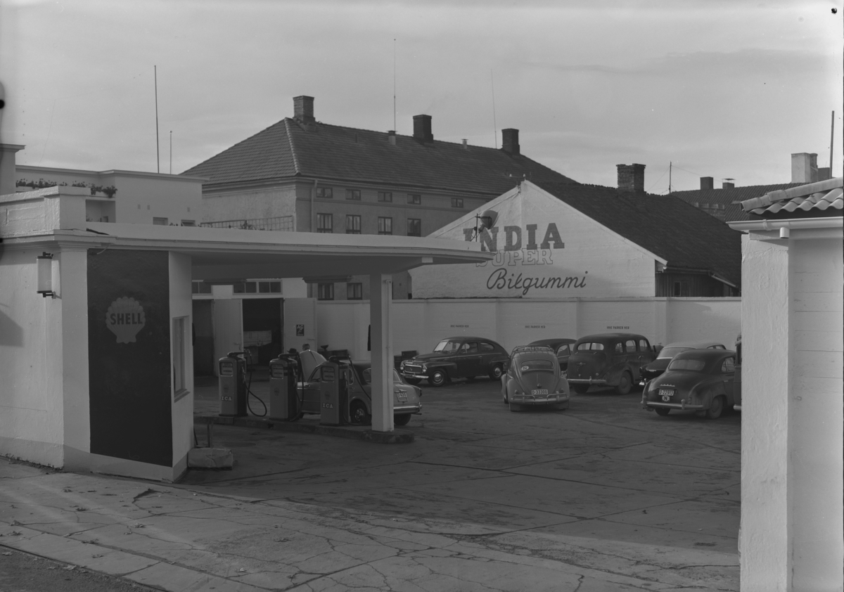 Eksteriørbilder fra Shell bensinstasjon, Østregate 41/Parkgata, Hamar.
Shell Bensindepot A/S. Dette var en av Hamars mange bensinstasjoner. Den ble grunnlagt i 1922, og bestyrer var Nils Hagen. Bedriften beskjeftiget åtte arbeidere og funksjonærer. Firmaet hadde to vaskehaller, tre oppvarmede smørehaller og tre elektriske bensinpumper.