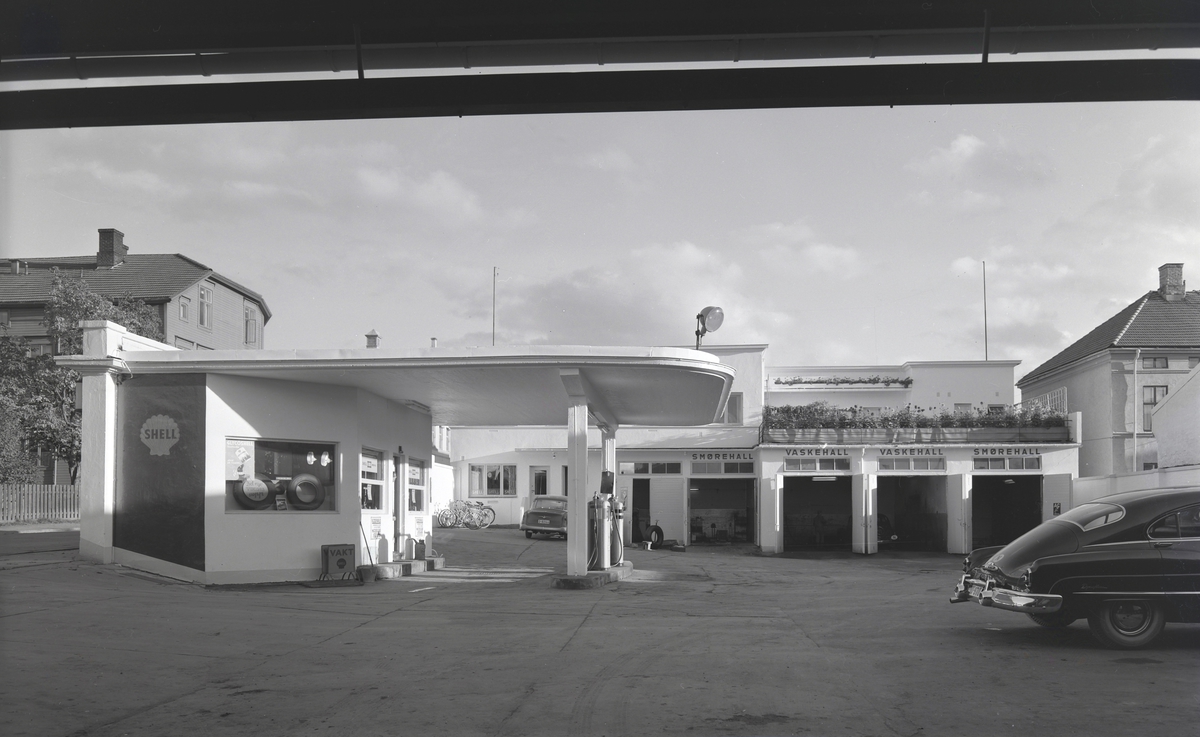 Eksteriørbilder fra Shell bensinstasjon, Østregate 41/Parkgata, Hamar. 
Shell Bensindepot A/S, Hamar. Dette var en av Hamars mange bensinstasjoner. Den ble grunnlagt i 1922, og bestyrer var Nils Hagen. Bedriften beskjeftiget åtte arbeidere og funksjonærer. Firmaet hadde to vaskehaller, tre oppvarmede smørehaller og tre elektriske bensinpumper.

Kilde: Det norske næringsliv, Hedmarks fylkesleksikon.