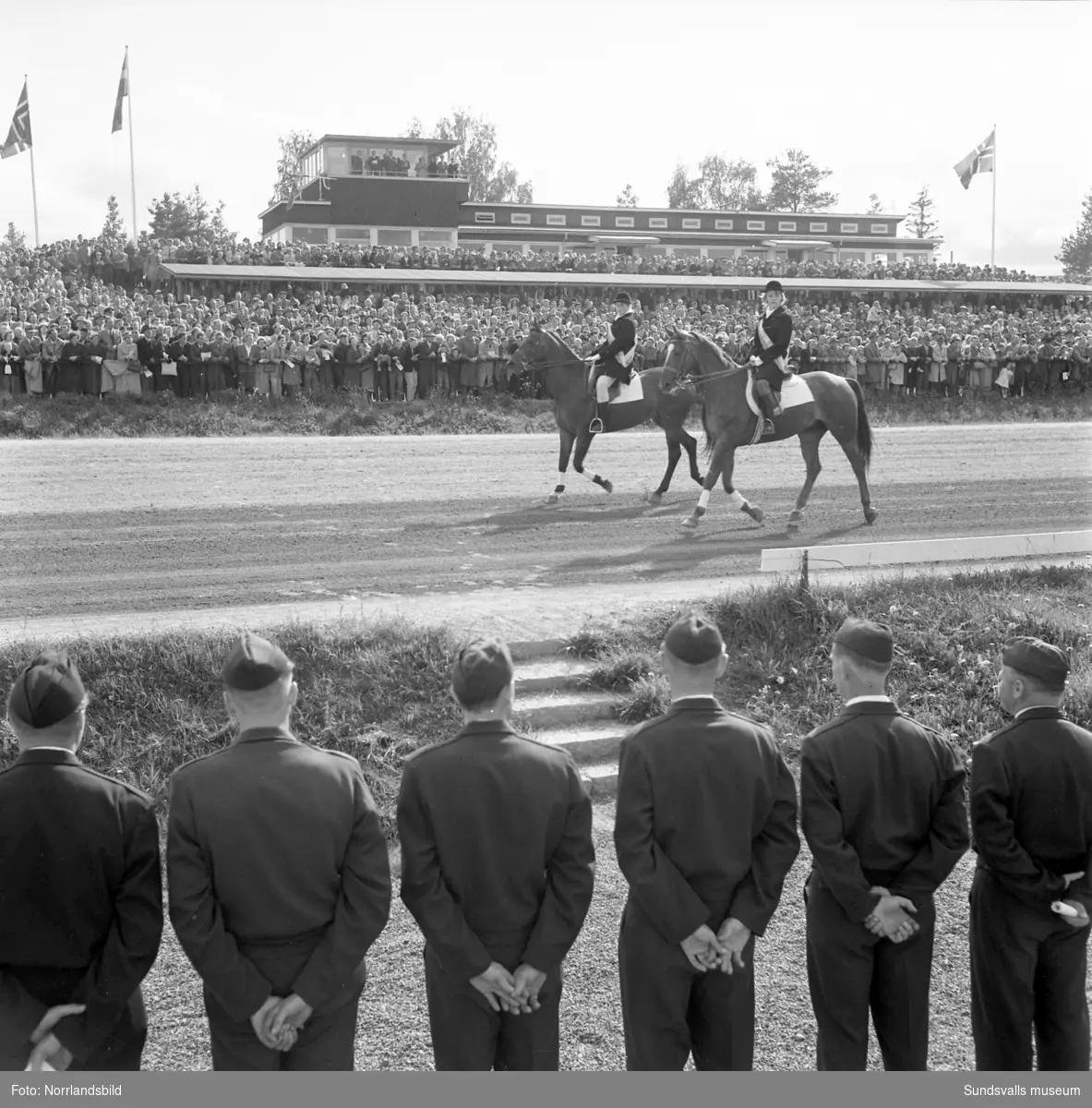 Svensk-Norska Kallblodslandskampen på Bergsåkerstravet 1959. Defileringen inleddes med förridare från Sundsvalls Ridklubb.