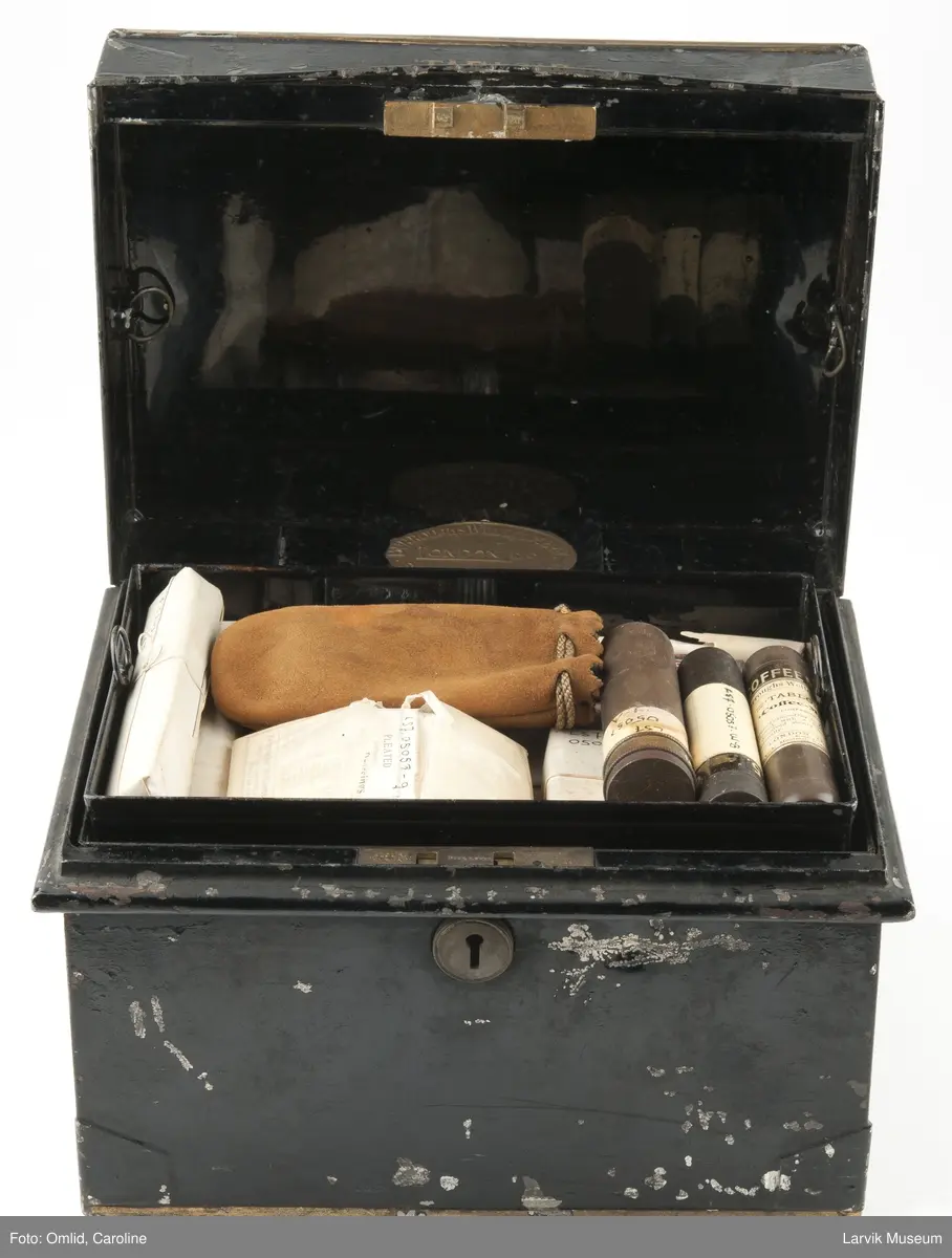 Sort metallskrin med diverse førstehjelpsutstyr. Et brev fra Oscar Wisting følger med:
"Dette medicinskrin har medfulgt Roald Amundsen påå hans ekspeditioner med "Fram" og "Maud". Jeg havde kapteinens ordre til at passe særlig omhyggelig paa dette skrin, hvis nøkkel han altid bar paa seg.
Horten, den 14de mars 1929
Ærbødigst
Oscar Wisting.

Gave til Larvik Sjøfartsmuseum fra Oscar Wisting 1929.