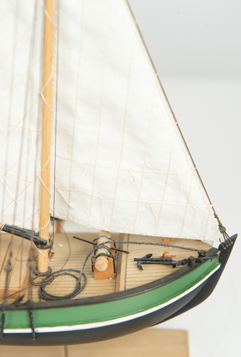 Riggad med fock och gaffelstorsegel. Svart skrov, grön bredgång. Vit kaltopp. Modellen tillverkad till utställningen "Seglande kungar, kungliga seglare", KSSS 150-årsjubileum 1980.