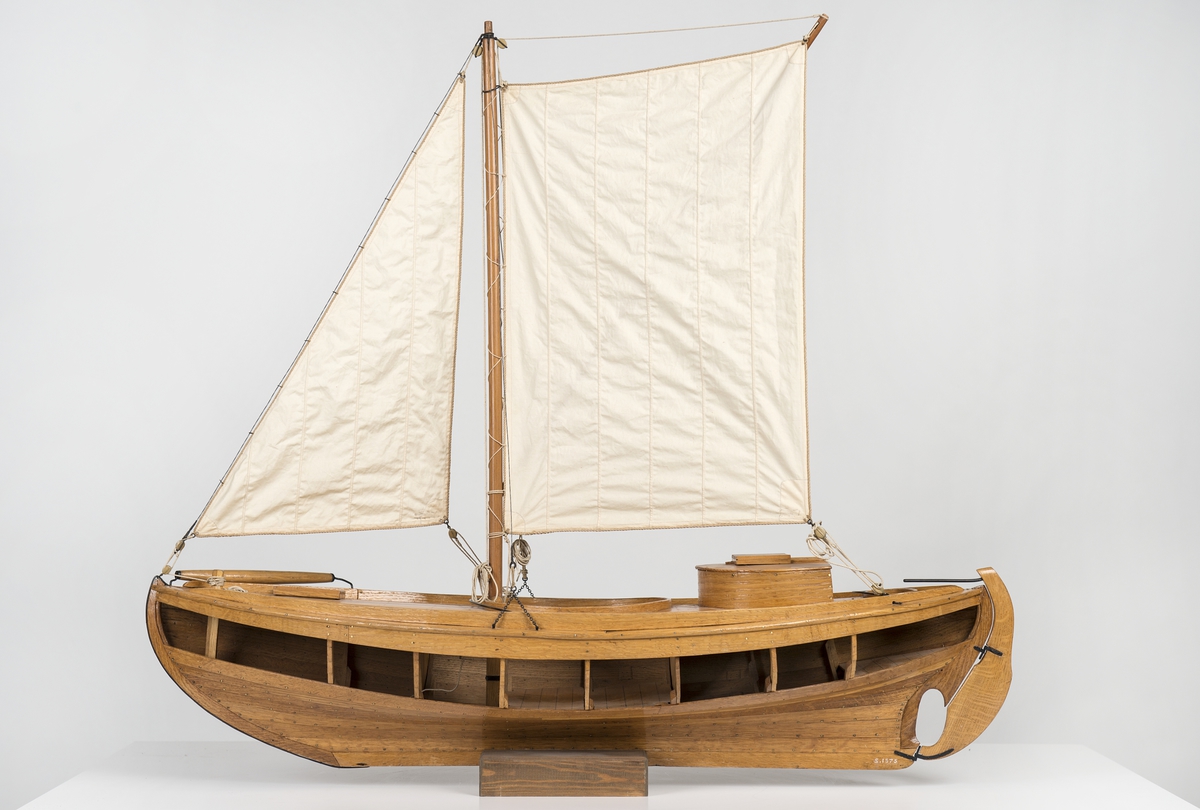 Modell av den för Öresund typiska sillfiskebåten Öresundskostern. Byggd på klink av ek, riggad, däckad fiskebåt. På styrbords bog rulle för dragningen av sillgarn. Akterut rund kapp med nedgångslucka till maskinrum. Reducerad rigg med låg mast, stagfock och sprisegel. Fartyget konstruerades av båtbyggaren A. R. Gustafsson i Landskrona, som även byggde modellen. Den korta kölen, fylliga övervattenskroppen och S-formade akterstäven är karaktäristiska drag för den senarste årtiondenas fiskefartyg. Babords sida öppen, rullbom på styrbords bog. Rund lastlucka och ruff över motorrummet. Kort mast i koger, med sprisegel och fock. Fyra lösa durkar, motor och propeller saknas. Skala 1:12.
Skrå saknas.