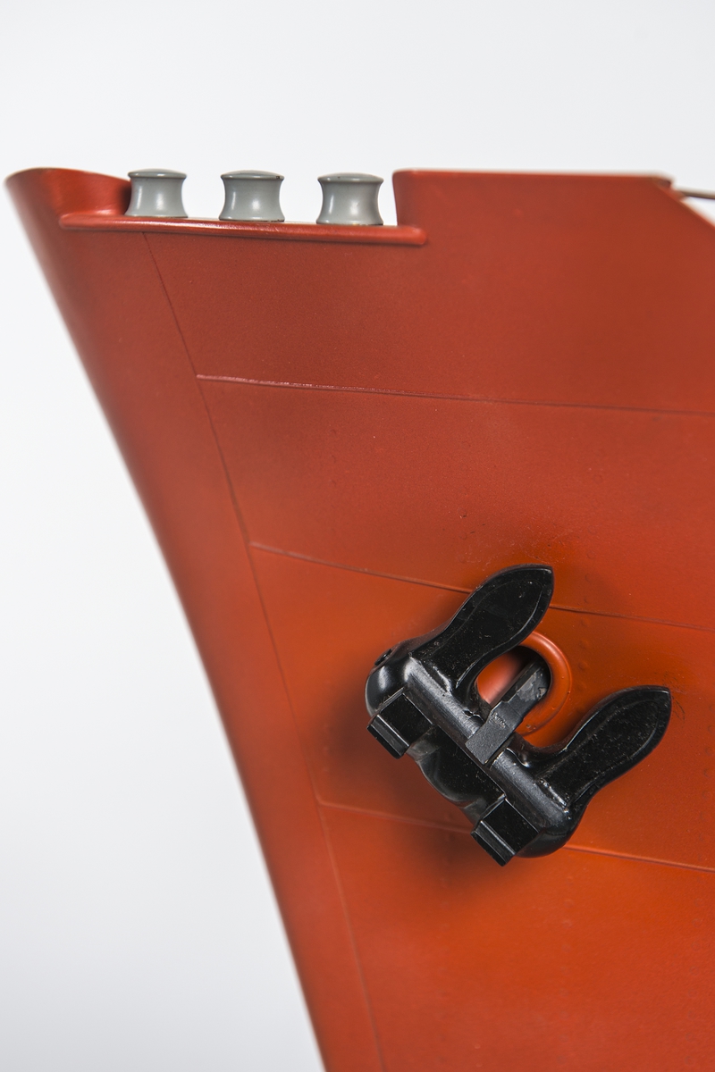 Modell av förskepp, från förstäv till mitten av l:ans lucka, byggd av metall, styrbords sida borttagen, visande konstruktionen med bottenstockar, spant, tanktak, skott och däck. Helt rödmålad. På backen gråmålat ankarspel och wirerullar. Under backen stor wirerulle. Två svarta ankare, stuvade i kättingbox.