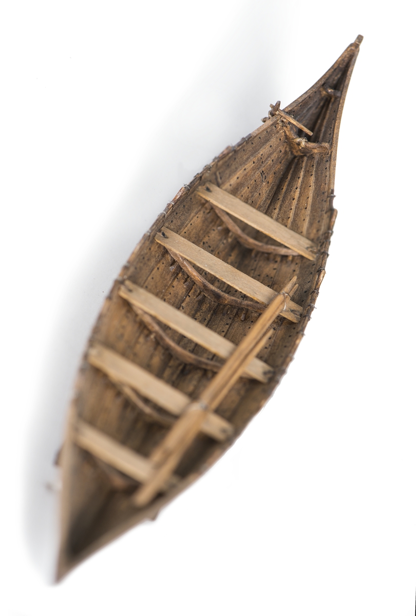 Rekonstruktion av gravbåt nr 2 från gravfältet vid Valsgärde i Uppland utgrävt 1928.
Skrov utfört i två halvor med limfog genom köl och stävar, bordläggningen skuren på såväl in- som utsidan. Klamparna på borden pålimmade. Håarna av grankvistar med självvuxen knagge, fastbundna med svartoxiderad suturtråd. Skrovet betsat i tjärfärg.
Inredning: 5 tofter, 4 åror samt styråra.