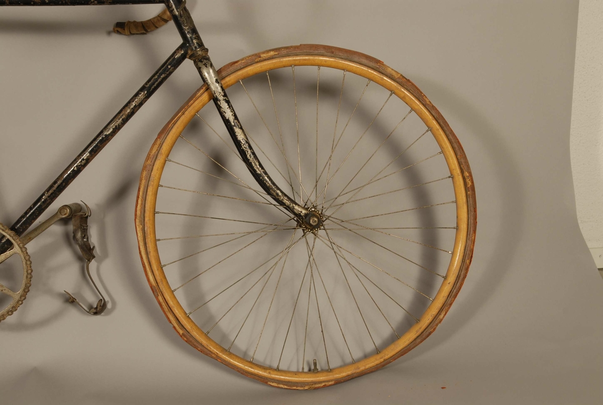Racer. Svart. Fälgarna av trä. Den främre gulmålad. Sadeln av svart läder. Läderrem fastbunden mellan ram och sadel. Styret delvis inlindat med ljust bomullsband. Märkt: Fram. Akt. Bol. Josef Eriksson, Velocipedfabrik, Uppsala. Sadeln märkt Brooks. På ramen handskriven text: Cyklist Ragge Malm.