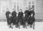 Elever vid vicekorpralskolan på F 3 Östgöta flygflottilj, 1940-1941. Nio stycken elever. Grupporträtt framför byggnad, vintertid.